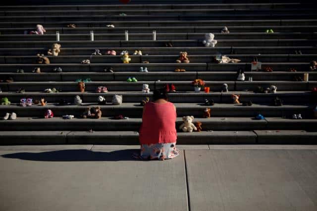 A member of the Tla-O-Qui-Aht First Nation pays her respects below the steps outside the legislature in Victoria on June 1.