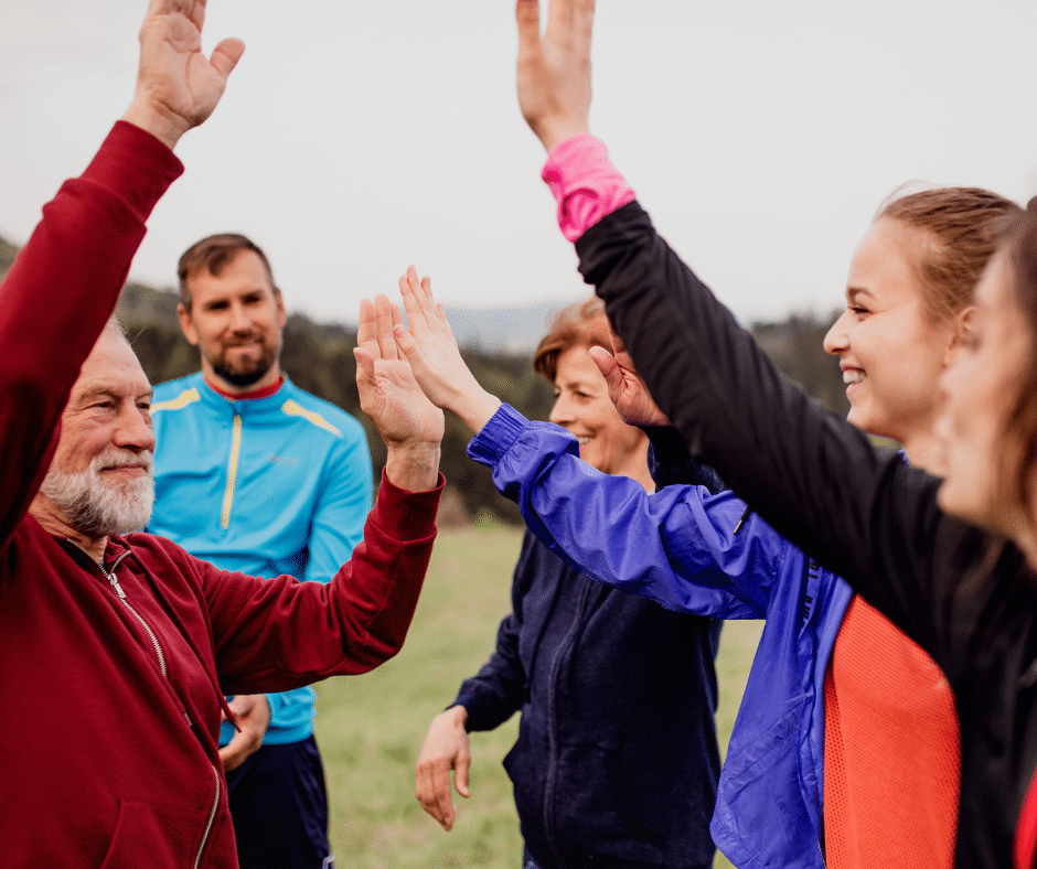 group of people high fiving outdoors