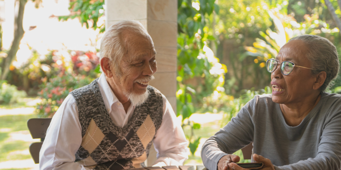 seniors smiling and conversing at a table